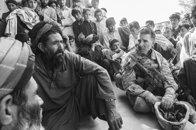 Soldier sits with Afghani men talking
