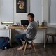 A man eating at a small desk