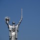 The Mother Motherland Monument statue in Kiev, showing a woman holding up a shield and sword