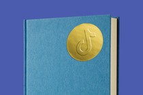 A book with a golden sticker showing TikTok's logo on the front