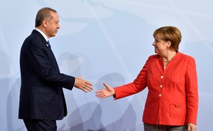 German Chancellor Angela Merkel greets Turkey's President Recep Tayyip Erdogan shake hands on stage at the G20.