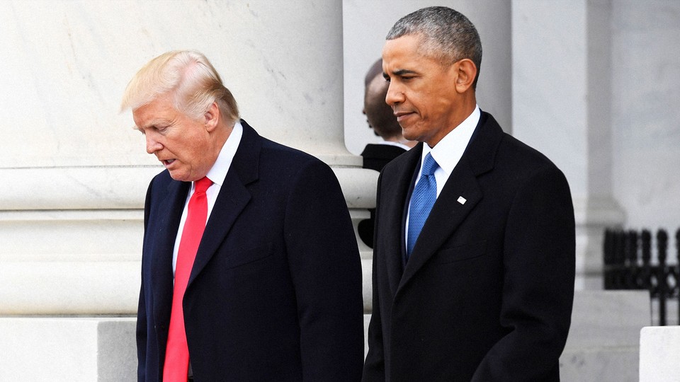 Donald Trump and Barack Obama walk and talk at the U.S. Capitol grounds. A marble pillar can be seen behind them.