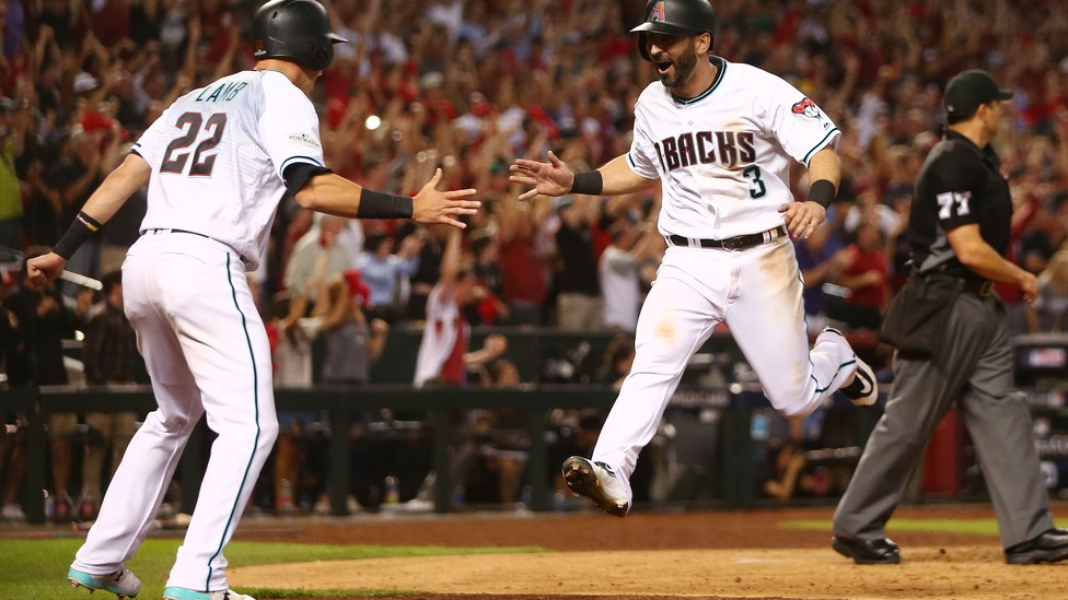 The Arizona Diamondbacks second baseman Daniel Descalso celebrates with the third baseman Jake Lamb after scoring runs in the 2017 National League wildcard playoff baseball game against the Colorado Rockies at Chase Field.