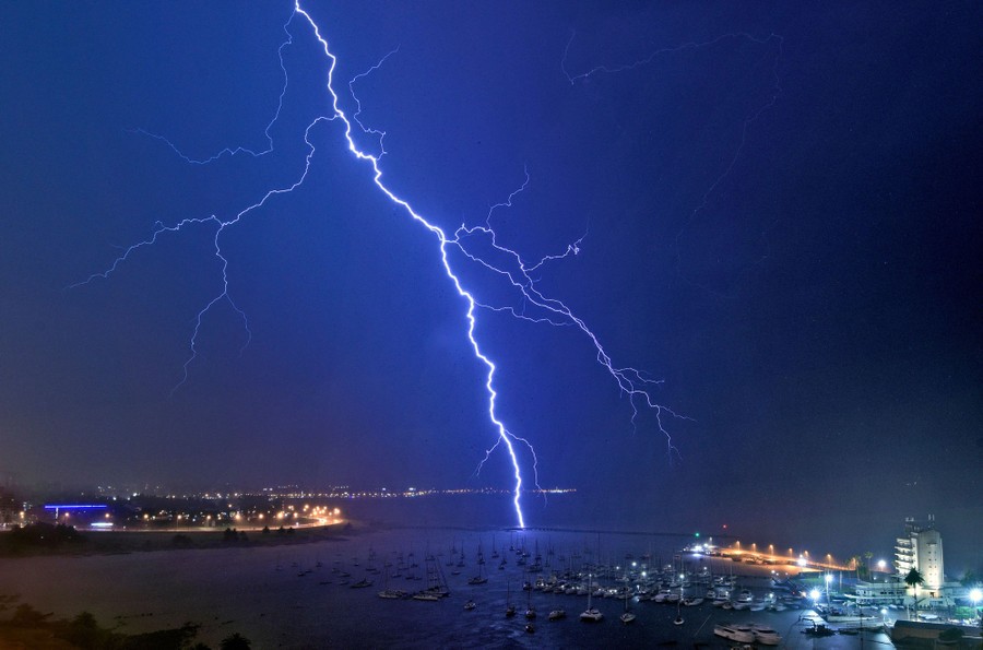 A lightning bolt strikes near a yacht club.
