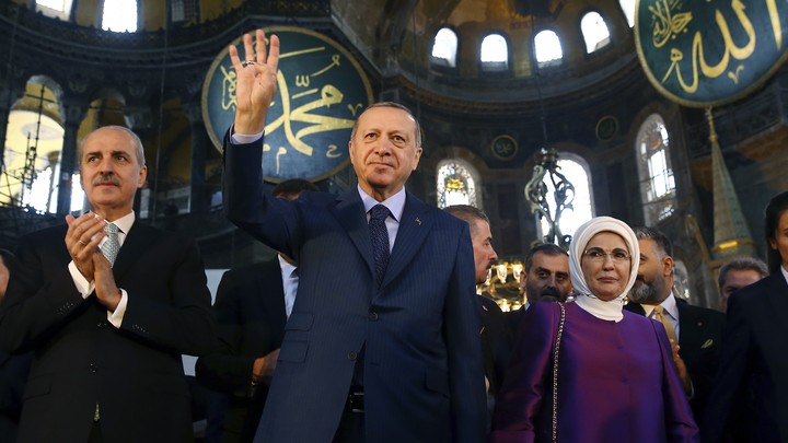 Erdoğan, center, accompanied by his wife, Emine, right, waves to supporters as he walks in the Byzantine-era Hagia Sophia, an UNESCO World Heritage site and one of Istanbul's main tourist attractions, in the historic Sultanahmet district of Istanbul. The sixth-century building is now at the center of a heated debate between conservative groups who want it to be reconverted into a mosque and those who believe the World Heritage site should remain a museum.