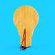 An illustration of a flat piece of wood that is shaped like a lightbulb and propped up by a wedge