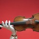 A person wearing white gloves holds up a violin