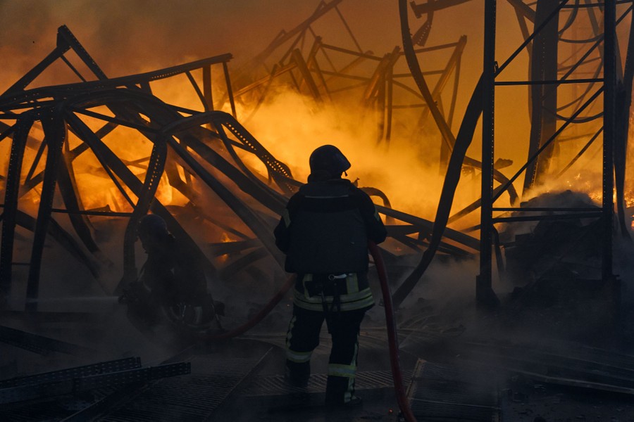 A firefighter works at the scene of a fire in a warehouse.