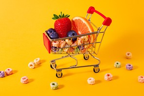 A miniature cart holding fruit slices and colorful cereal