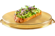 A photo-illustration of avocado toast on top of a golden platter