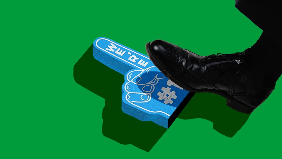 A foot steps on a blue "We're #1" foam hand.