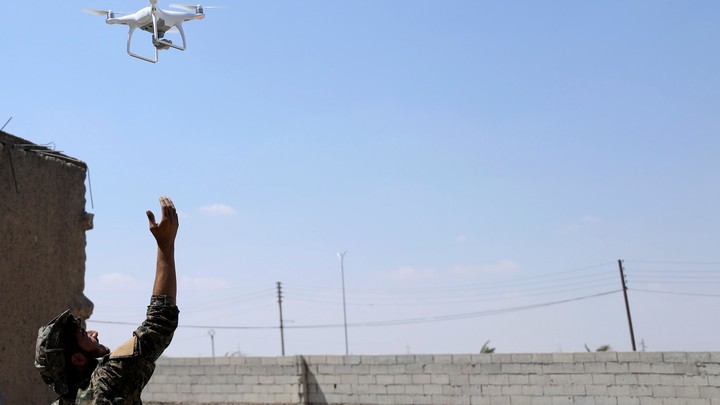 A fighter from SDF flies a drone in western Raqqa province on June 18, 2017.