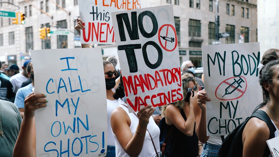 Anti-vaccine protesters holding up signs