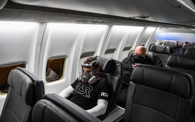 A man wears a gasmask as he travels in a flight from Miami to Atlanta in Miami, on April 23, 2020