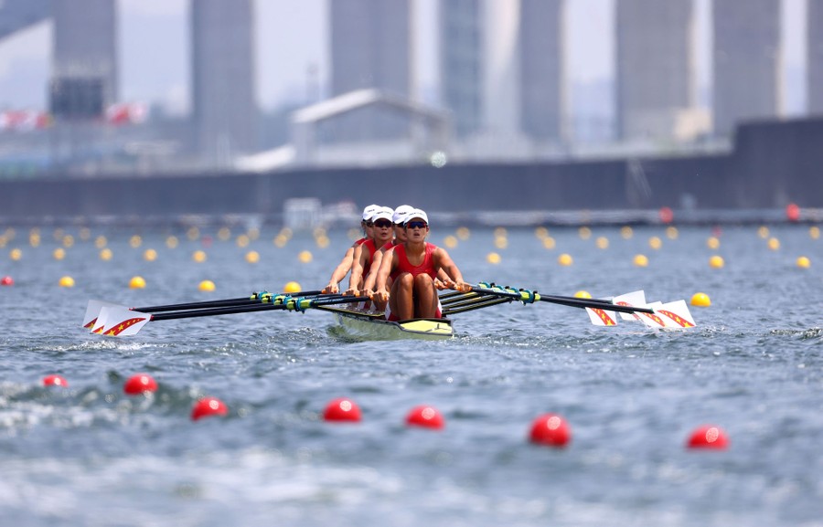 Four people row through a course.