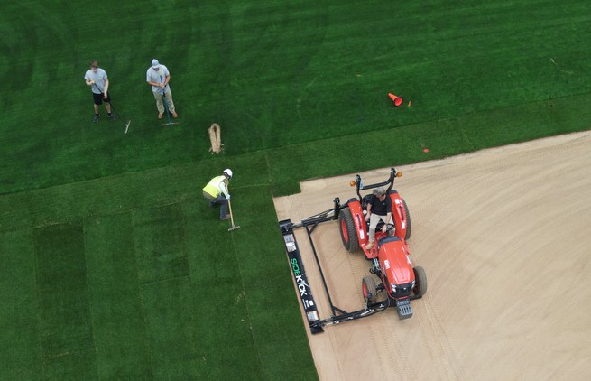 World Cup workers prepare the field in a stadium