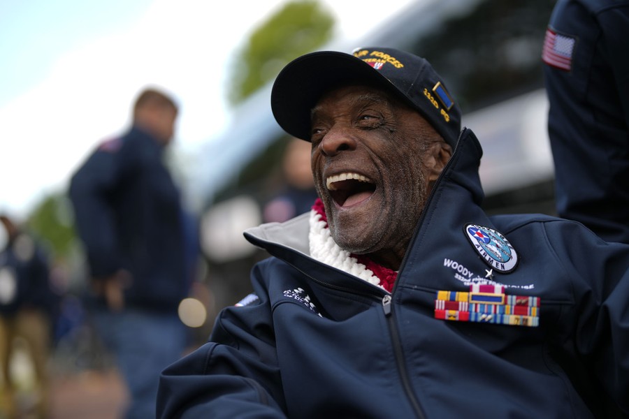 An elderly American veteran with several colorful medals smiles broadly.