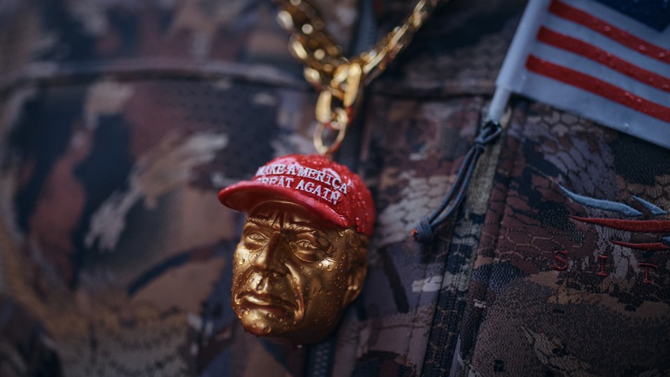 An amulet of a man in a MAGA hat over military camouflage