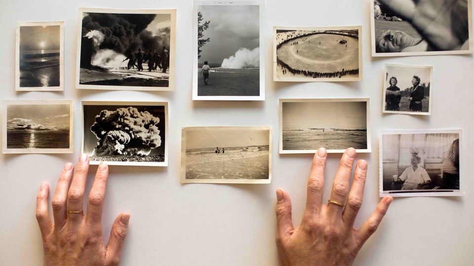 Amelia Walker's hands hover over her collection of snapshots.