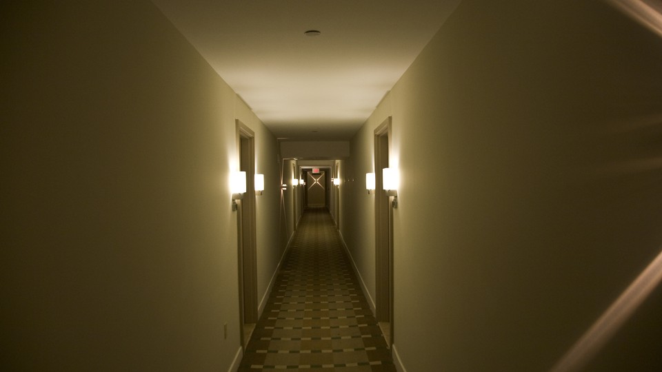 A long, dimly lit hallway with a patterned rug