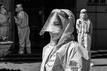 Workers and volunteers look on in a compound where residents are tested for the coronavirus during the second stage of a pandemic lockdown in Jing'an district, in Shanghai, on April 4, 2022.