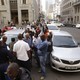 Uber taxi drivers in South Africa stand near their cars and block a road during a protest