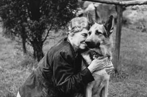 Helen Keller hugs her German Shepherd