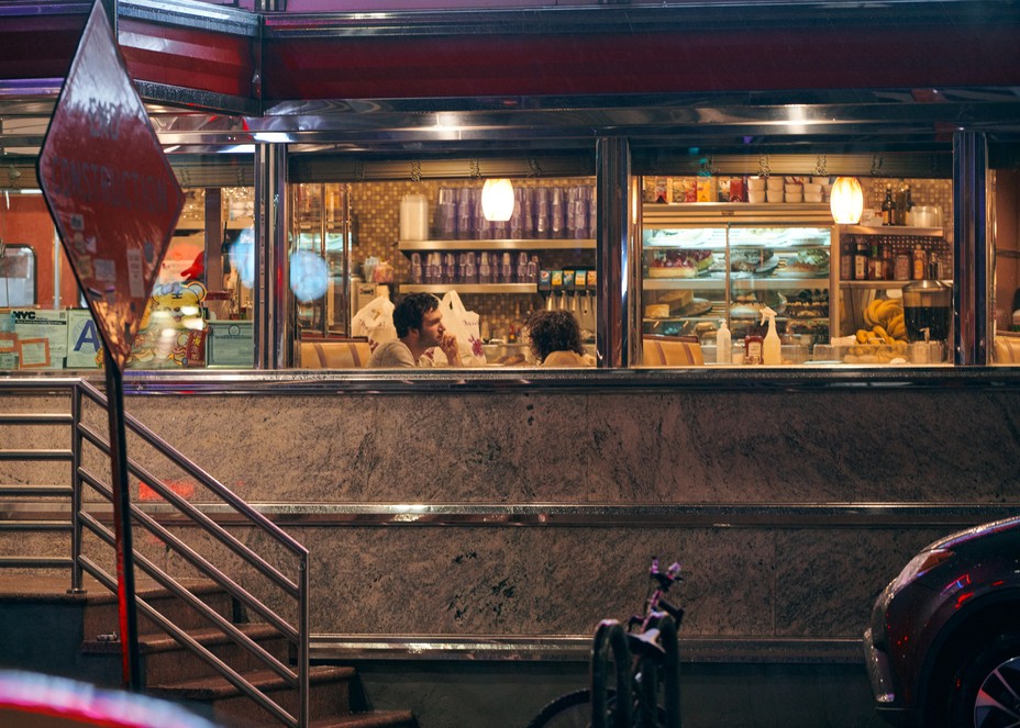 people seen through a diner window at night