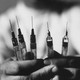 A man holding syringes