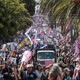 Demonstrators hold signs as they march down a city street.