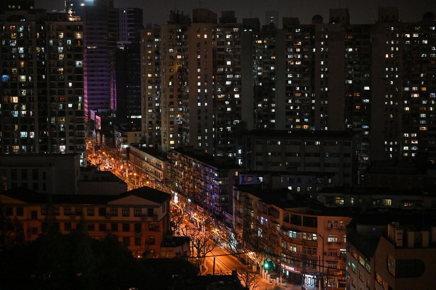 A view of a residential area at night, including tall buildings with many lit-up windows