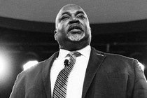 Black-and-white photo of Mark Robinson with a microphone attached to his tie