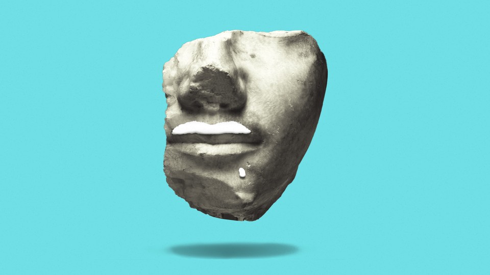 Image of a weathered sculpture of a face with a milk mustache