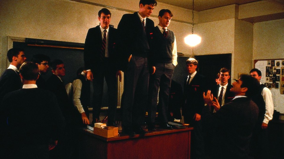 In a scene from "Dead Poets Society," students stand on a desk in a classroom.