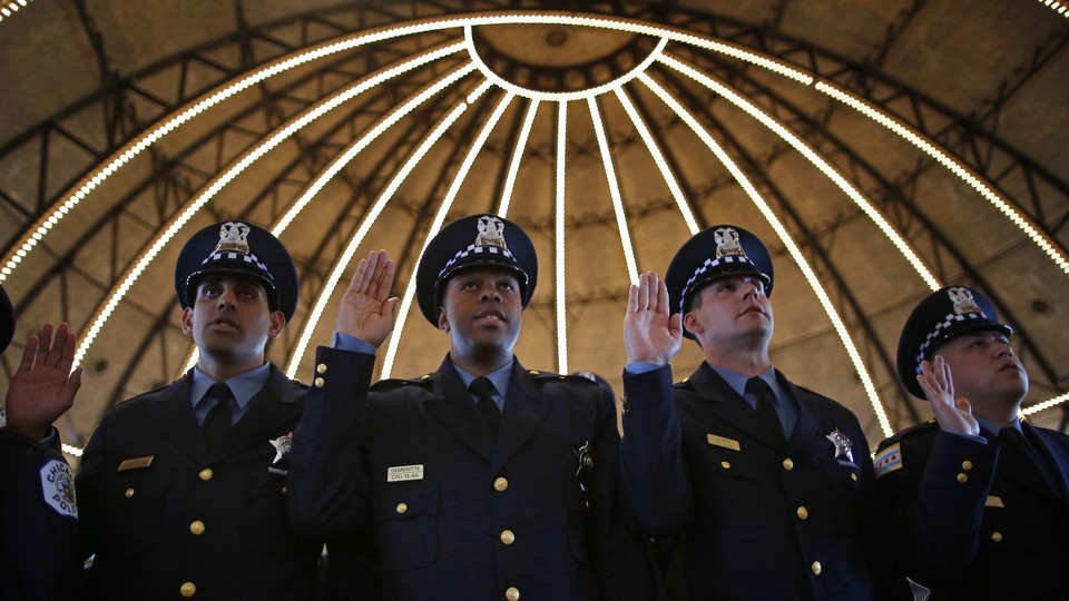 Chicago Police officers line up to be presented their certificates during the graduation ceremony for the Department's newest recruits in Chicago, Illinois, April 21, 2014.