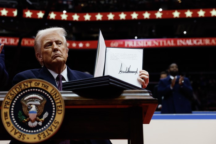 Trump holds up a signed executive order