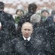 Russian President Vladimir Putin stands in the snow at a wreath laying ceremony.