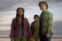 three kids standing in front of an eerie beach
