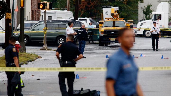 Law enforcement officers mark evidence near the site where Ahmad Khan Rahami, sought in connection with a bombing in New York, was taken into custody in Linden, New Jersey,