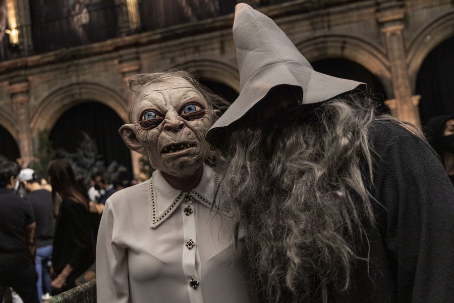 Two people pose while wearing costumes, one dressed as Gollum and the other as Gandalf from "The Lord Of The Rings."