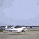 A small winged aircraft hovers a few feet above the tarmac.