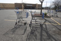 Shopping carts are shown in the parking lot of a Walmart store in California.