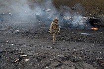 A soldier is seen walking through wreckage.