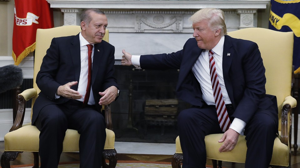 Trump pats Erdoğan on the back during a meeting in the Oval Office.