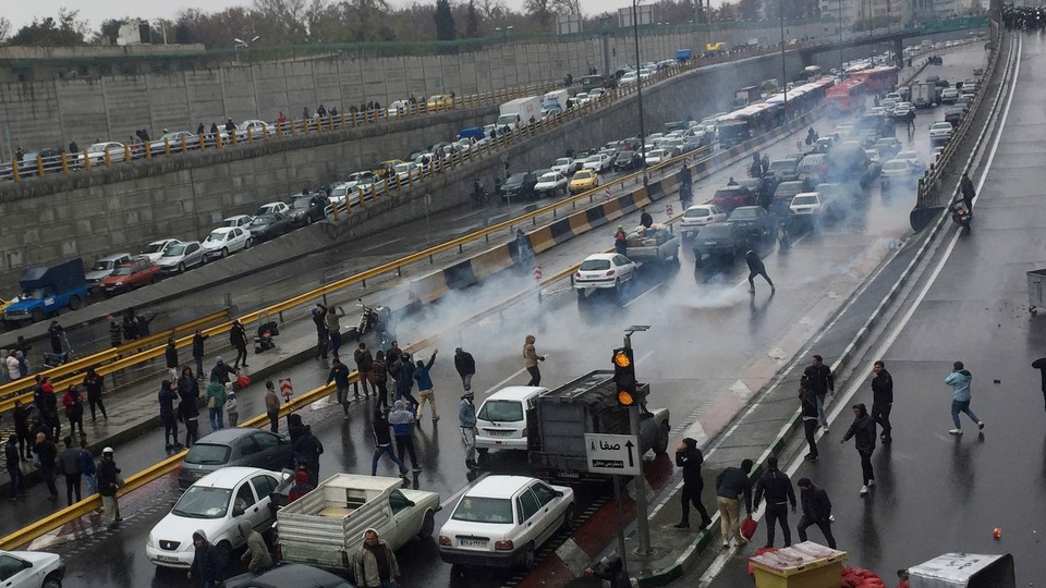 People park their cars on a crowded highway in Tehran to protest rising gas prices.