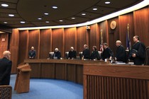 Justices in robes stand in a courtroom. 