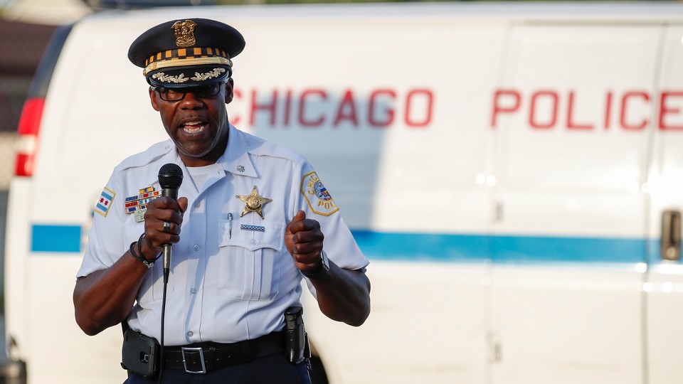 Chicago Police District Commander Kenneth Johnson, wearing his uniform and holding a microphone, speaks during an anti-violence rally in Chicago in July.