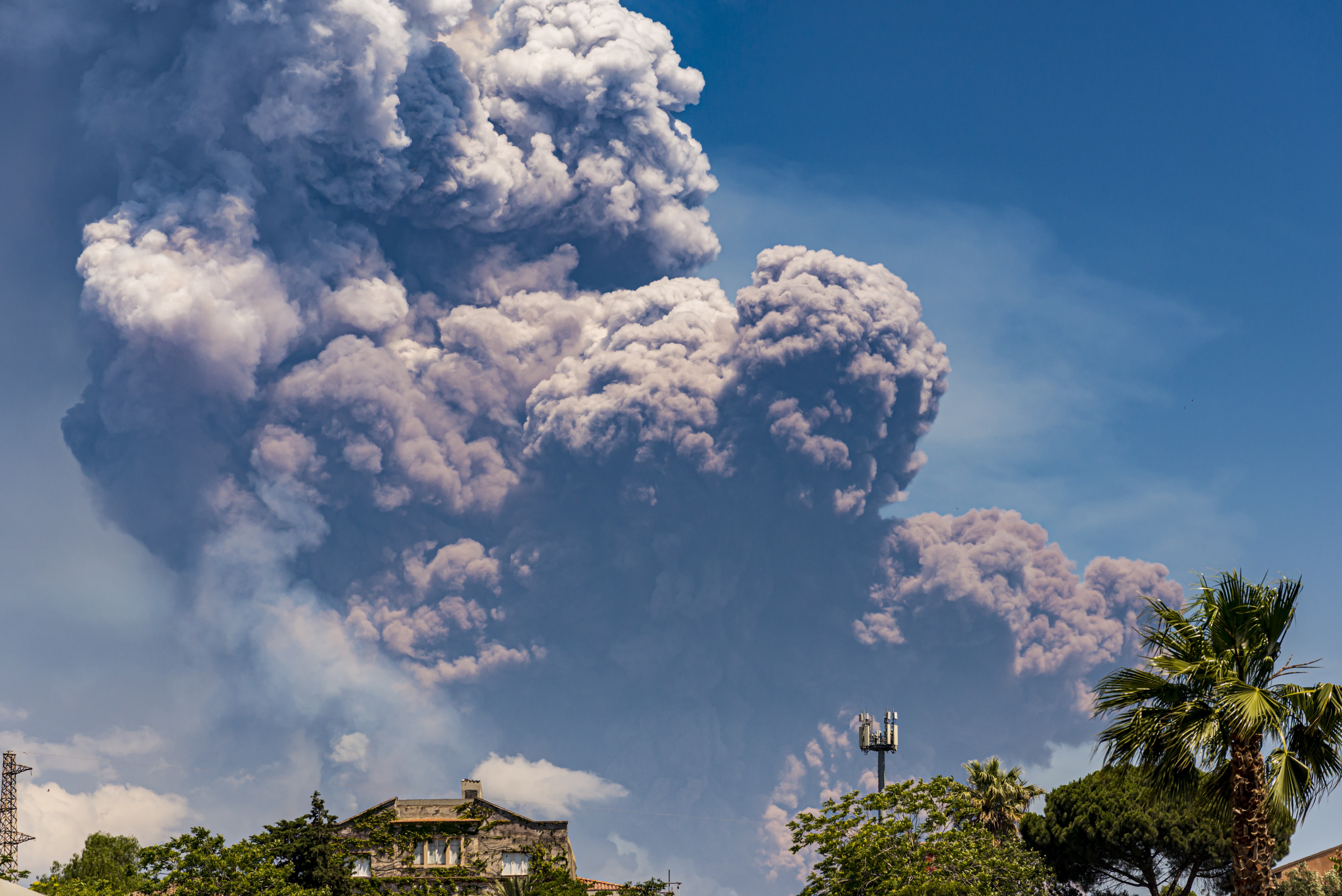 A tall cloud of gas and ash above a volcano
