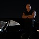 Vin Diesel stands with his arms crossed while leaning against a car, at night, in "Fast X"