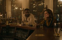 A still from the Apple TV+ series 'Slow Horses' showing two characters sitting at a bar
